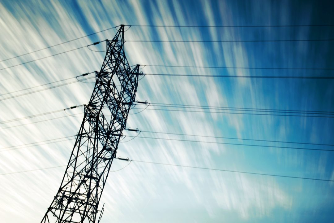 Electricity transmission tower against blurry sky.
